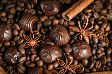 Assortment of white, dark, and milk chocolate. Chocolate with cream, nuts, almonds, hazelnuts and cinnamon with coffee beans. Sweet food and no diet concept.