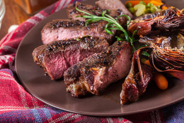 Slices of beef steak served with baked artichoke