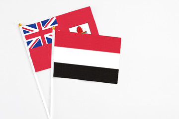 Yemen and Bermuda stick flags on white background. High quality fabric, miniature national flag. Peaceful global concept.White floor for copy space.