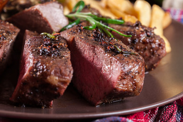 Slices of beef steak served with baked artichoke