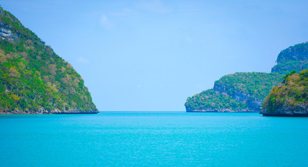 Fototapeta na wymiar Islands green lush tropical island in a blue and turquoise sea background