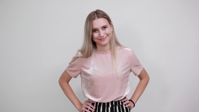 Young funny beautiful caucasian woman wearing nice pink shirt puffing cheeks with funny face, putting hands on . Mouth inflated with air, crazy expression.