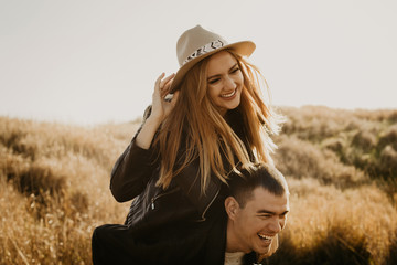 Happy young couple enjoying outdoors during sunset .