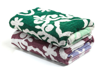 Pile of colored towels isolated on white background .