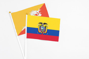 Ecuador and Bhutan stick flags on white background. High quality fabric, miniature national flag. Peaceful global concept.White floor for copy space.