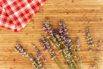 Lavender and checked red and white cloth towel on wooden table, top view flatlay, wellness