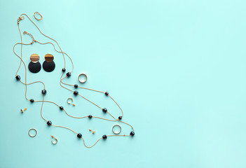 Stylish female jewelry on color background