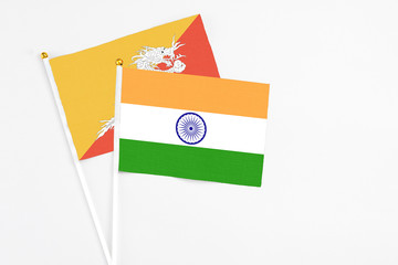India and Bhutan stick flags on white background. High quality fabric, miniature national flag. Peaceful global concept.White floor for copy space.