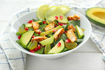 Bowl with tasty chicken salad on table