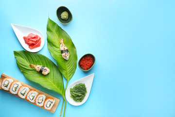 Composition with tasty sushi on color background