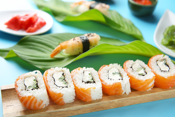 Set of tasty sushi rolls on color background