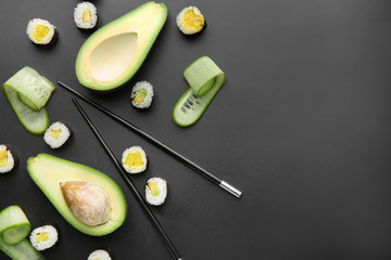 Composition with tasty sushi and avocado on dark background