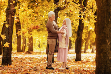 Loving mature couple dancing in autumn park