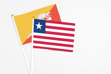 Liberia and Bhutan stick flags on white background. High quality fabric, miniature national flag. Peaceful global concept.White floor for copy space.