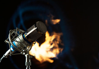 Metal blue microphone on a fire and black background  toning photo
