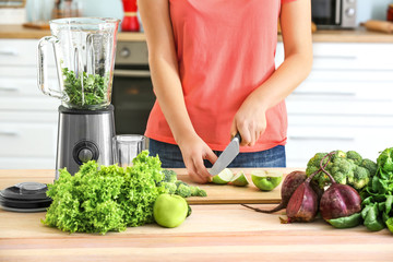 Woman preparing healthy smoothie in kitchen