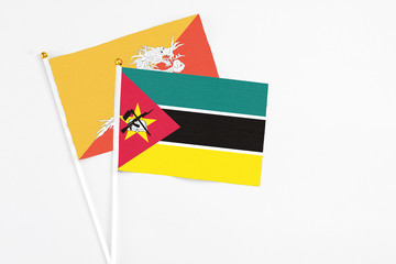 Mozambique and Bhutan stick flags on white background. High quality fabric, miniature national...
