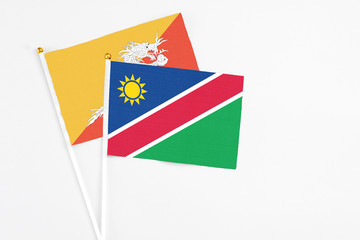 Namibia and Bhutan stick flags on white background. High quality fabric, miniature national flag. Peaceful global concept.White floor for copy space.