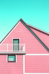 Obraz premium Pink minimalistic house architecture with balcony and cyan sky above roof