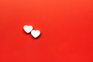 Two white heart pills on a red background with place for text.