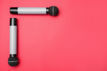 Modern microphones on color background