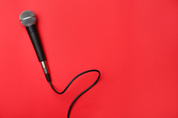 Modern microphone on color background