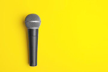Modern microphone on color background