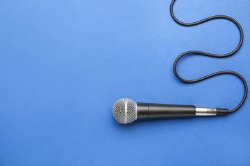 Modern microphone on color background