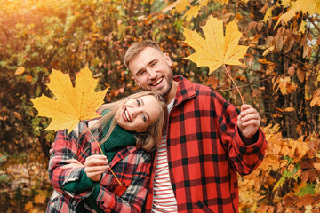 Loving young couple with autumn leaves in park