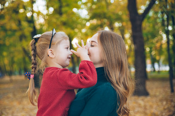 mother daughter love hug at autumn city park