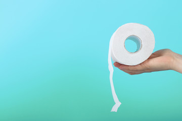 White toilet paper roll in female hand, concept of constipation or diarrhea