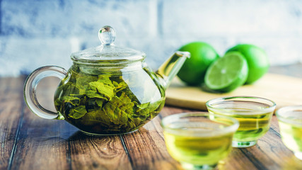 The tea leaves are brew in boiling water and infuse in a small teapot. The concept of the tea party. Green tea in a teapot