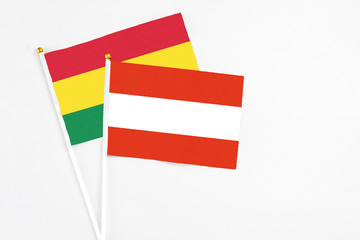 Austria and Bolivia stick flags on white background. High quality fabric, miniature national flag. Peaceful global concept.White floor for copy space.