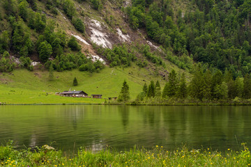 berghütte vor einem berghang an einem bergsee an einem regnerischen wolkigen Sommertag