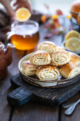 Oriental dessert gata with a cup of tea and tangerines on a wooden table. Selective focus