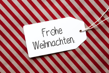 Label With German Calligraphy Frohe Weihnachten Mean Merry Christmas. Red Wrapping Paper As Background