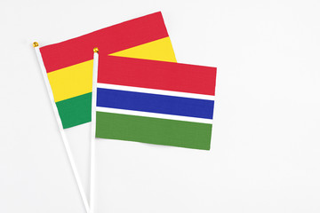 Gambia and Bolivia stick flags on white background. High quality fabric, miniature national flag. Peaceful global concept.White floor for copy space.