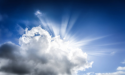 Blue sky with dramatic clouds and sun rays reflection.