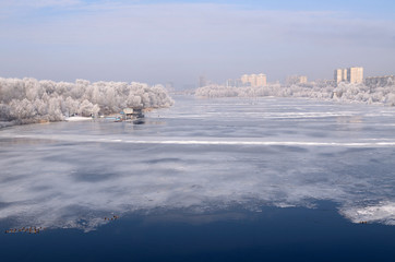 Winter view of the Dnieper river, the barge moored, trees in hoarfrost, buildings of the Kiev city on a background.  Hydro-park, Kiev, Ukraine 