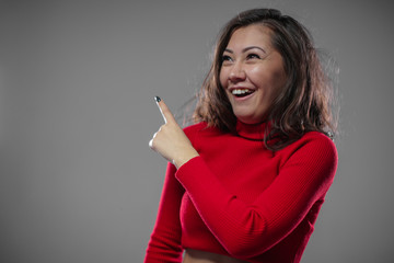 Woman provocatively laughs and points far the upward. © Anton