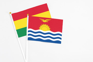 Kiribati and Bolivia stick flags on white background. High quality fabric, miniature national flag. Peaceful global concept.White floor for copy space.