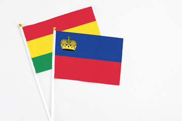 Liechtenstein and Bolivia stick flags on white background. High quality fabric, miniature national flag. Peaceful global concept.White floor for copy space.