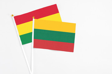 Lithuania and Bolivia stick flags on white background. High quality fabric, miniature national flag. Peaceful global concept.White floor for copy space.