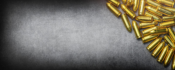 Bullets ammunition on stone table wide banner or panorama. Bullet pile background copy space.  Ammo...