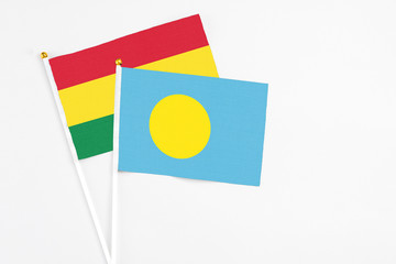 Palau and Bolivia stick flags on white background. High quality fabric, miniature national flag. Peaceful global concept.White floor for copy space.