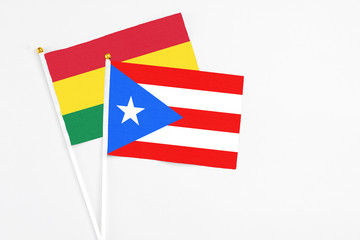 Puerto Rico and Bolivia stick flags on white background. High quality fabric, miniature national flag. Peaceful global concept.White floor for copy space.