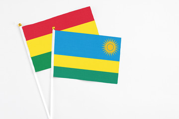 Rwanda and Bolivia stick flags on white background. High quality fabric, miniature national flag. Peaceful global concept.White floor for copy space.