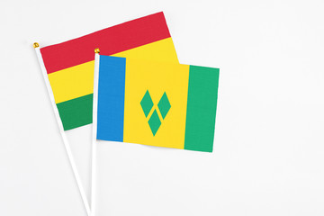 Saint Vincent And The Grenadines and Bolivia stick flags on white background. High quality fabric,...