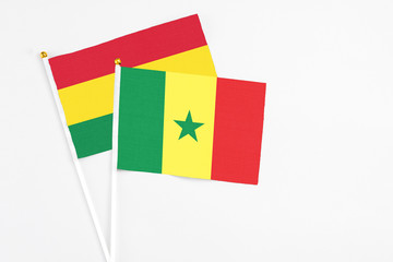 Senegal and Bolivia stick flags on white background. High quality fabric, miniature national flag. Peaceful global concept.White floor for copy space.