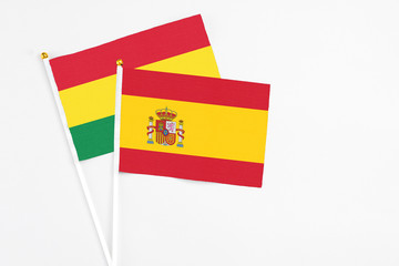 Spain and Bolivia stick flags on white background. High quality fabric, miniature national flag. Peaceful global concept.White floor for copy space.